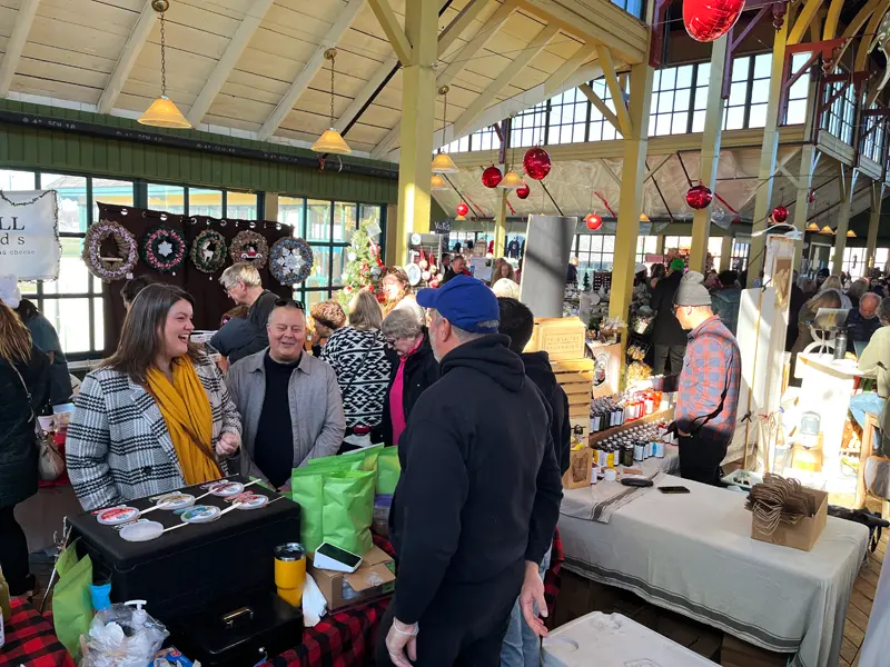 Fresh winter greenery, wreaths, and local organic produce on display at the Picton holiday market.